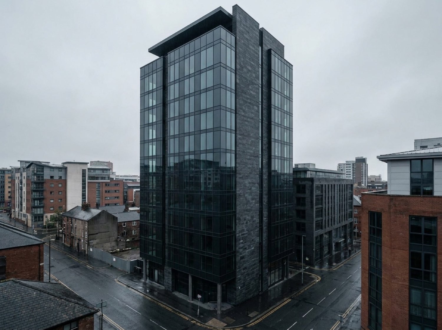 PartyQueueCrew exterior by day — dark glass and stone tower, overcast Leeds sky