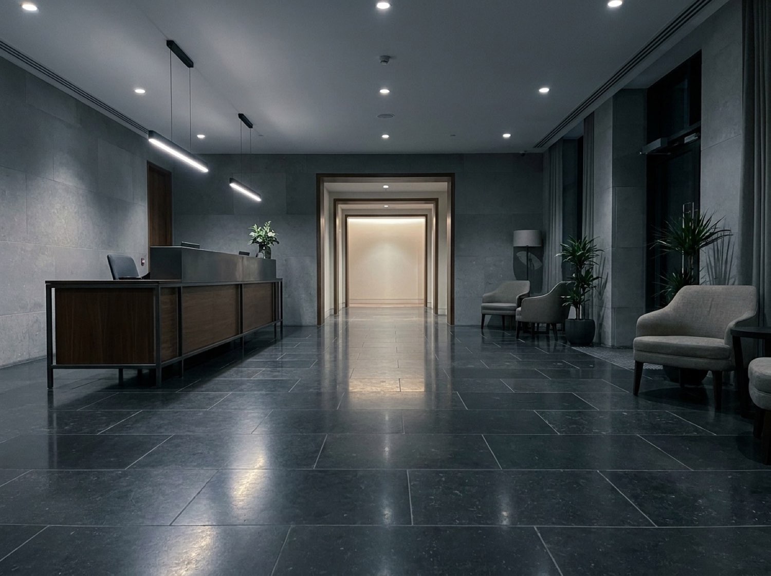 PartyQueueCrew lobby — dark stone floor, low reception desk, framed corridor
